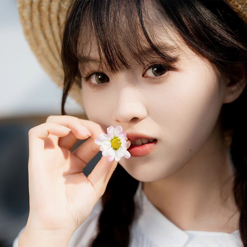 Portrait of a young woman in a straw hat holding a daisy, sample from the Viltrox 56mm f/1.7