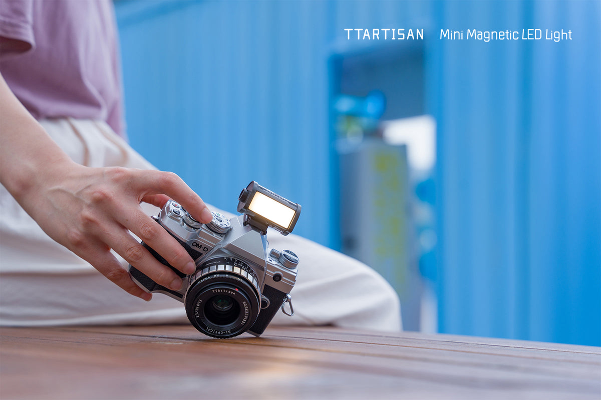 Silver film camera with the TTArtisan mini magnetic LED light on the hot shoe