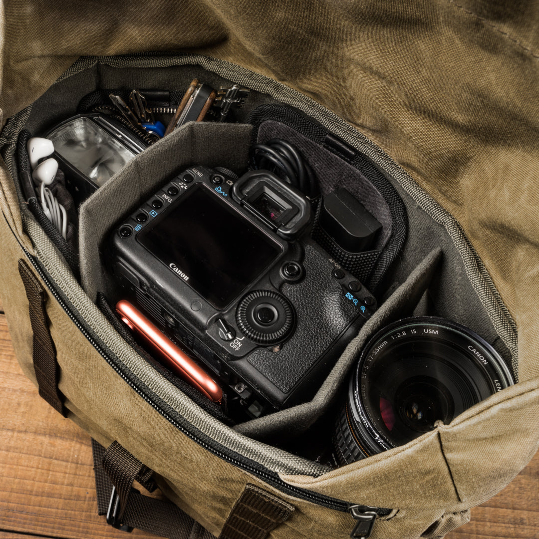 Wotancraft Pilot 10L khaki bag open with a Canon DSLR, lens and flash in the insert