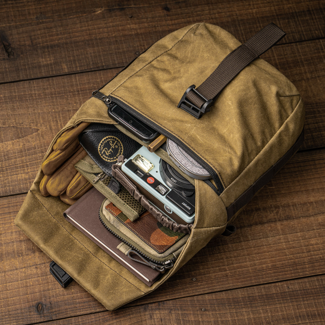 Wotancraft Pilot 3.5L khaki bag open with gloves, instant camera and accessories