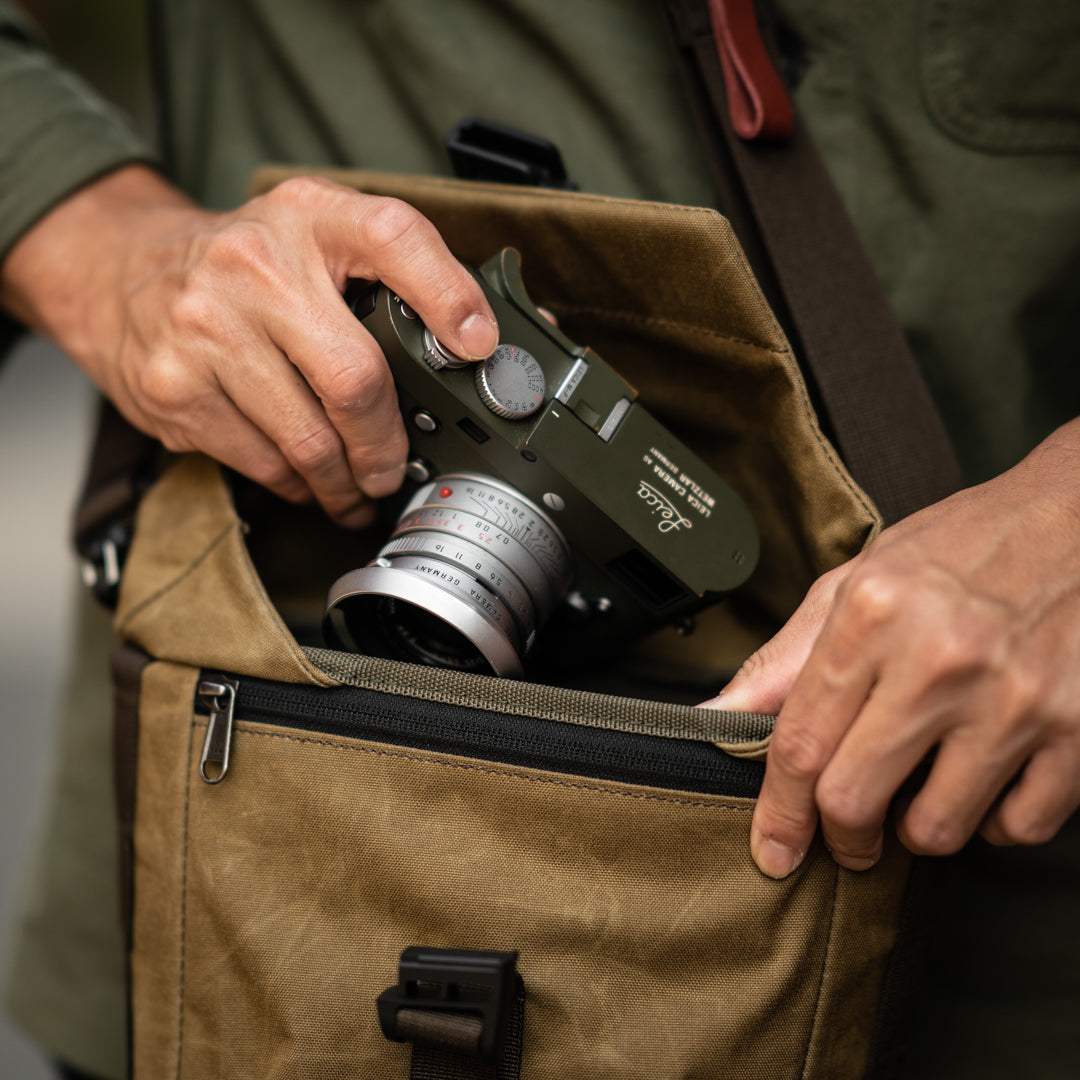 Hands taking a Leica camera out of the Wotancraft Pilot 3.5L khaki bag