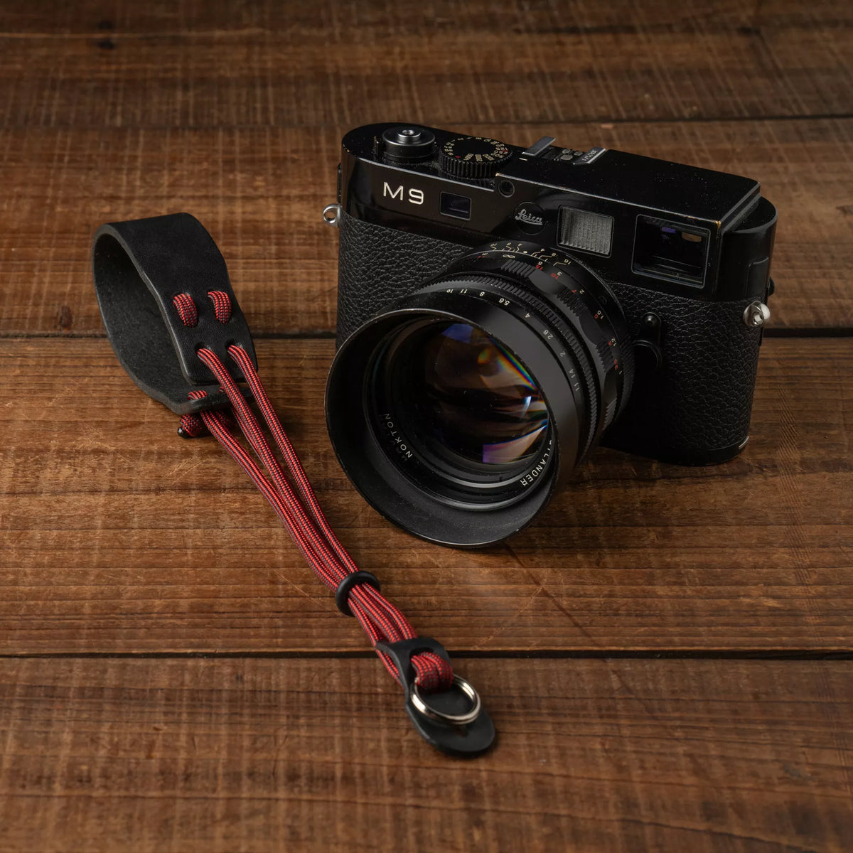 Wotancraft Parashooter Style 11 wrist strap next to a black Leica M9