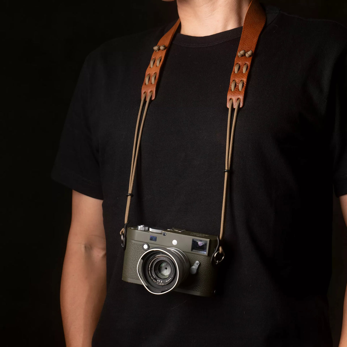Person wearing a Leica M camera on the Wotancraft Parashooter Style 3 tan strap