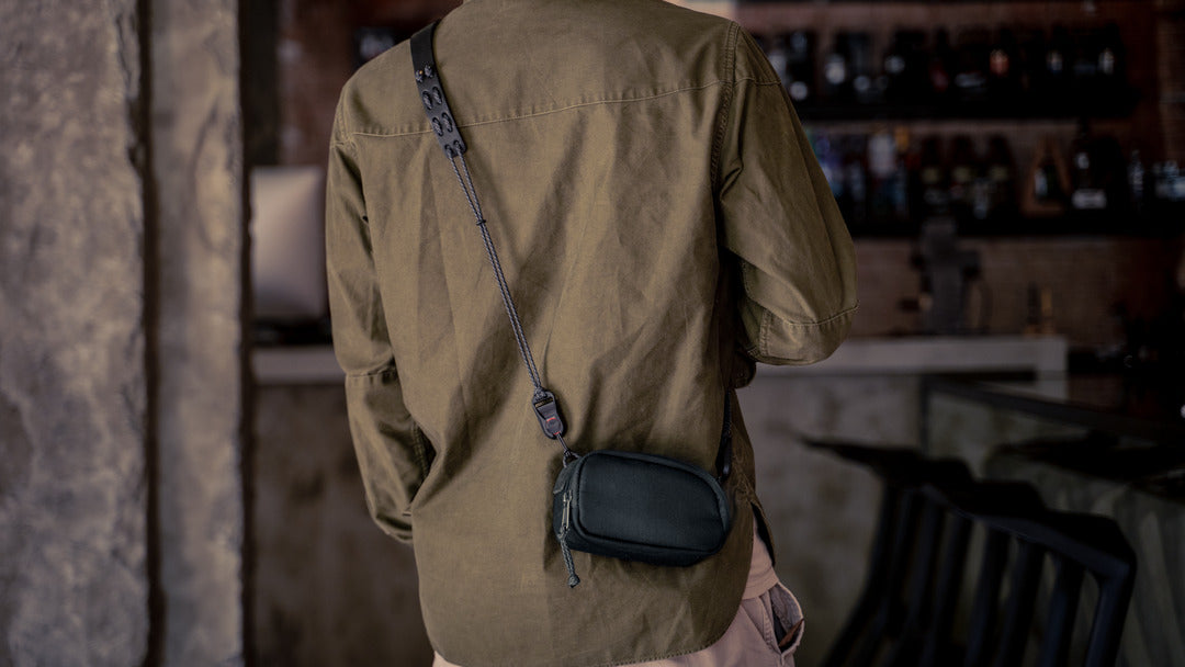Man wearing the Wotancraft small black canvas pouch across the back