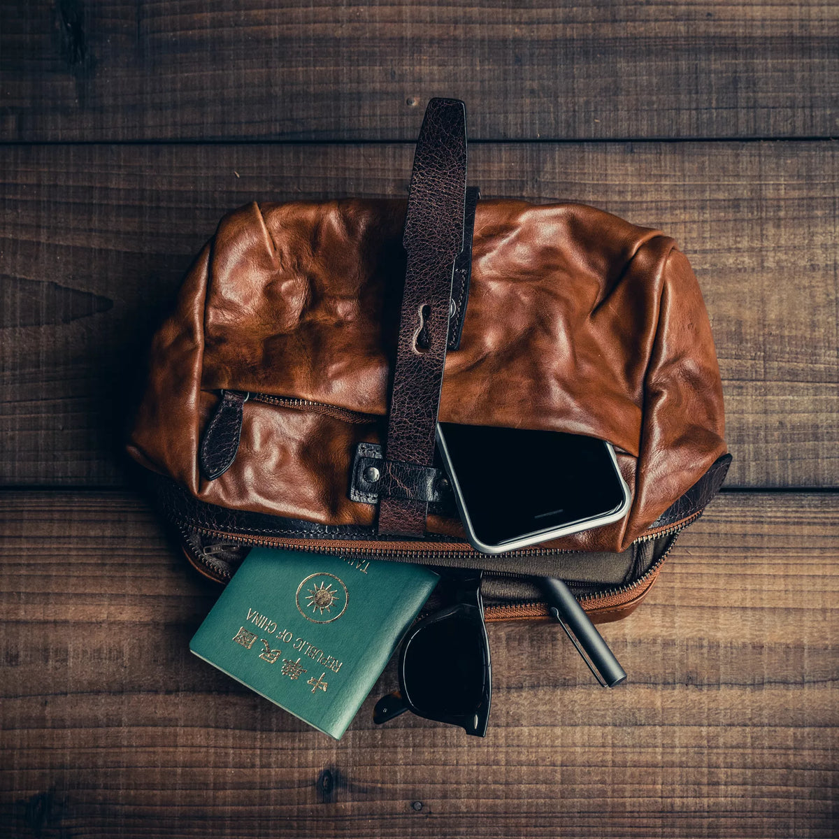 Wotancraft Mini Rider brown leather bag with passport, phone and sunglasses