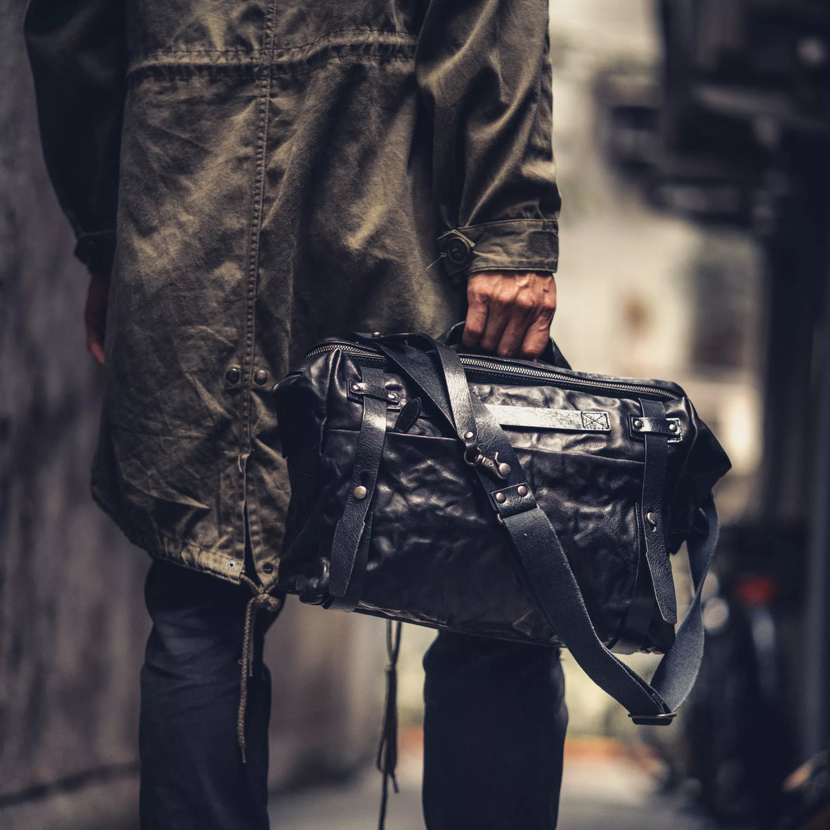 Man holding the Wotancraft Lightning Rider black leather bag with shoulder strap