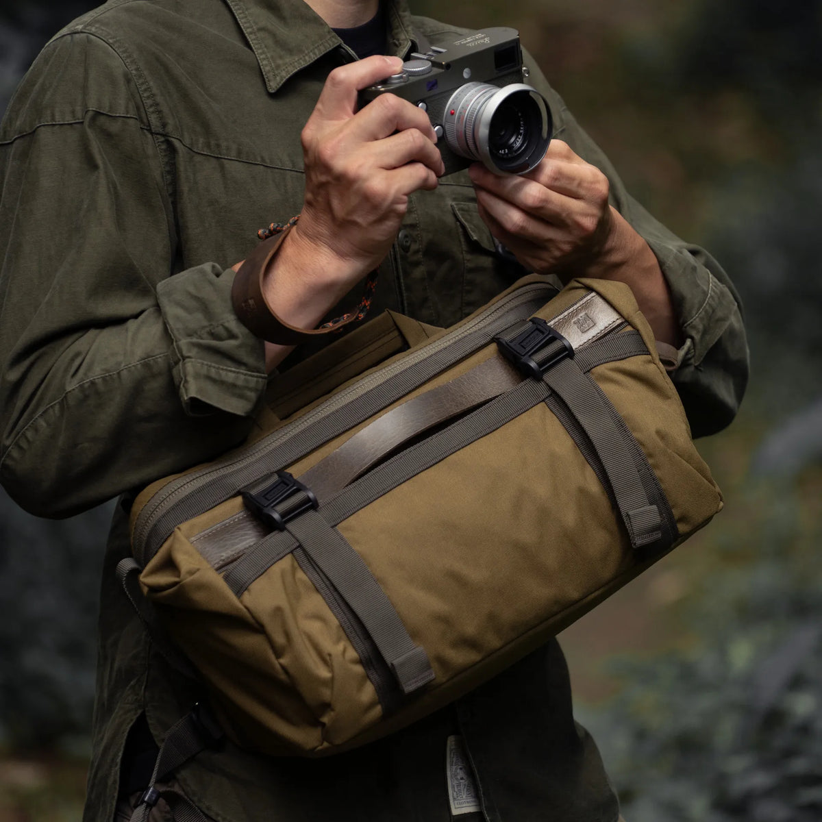 Man holding a Leica camera with the Wotancraft Easy Rider khaki bag