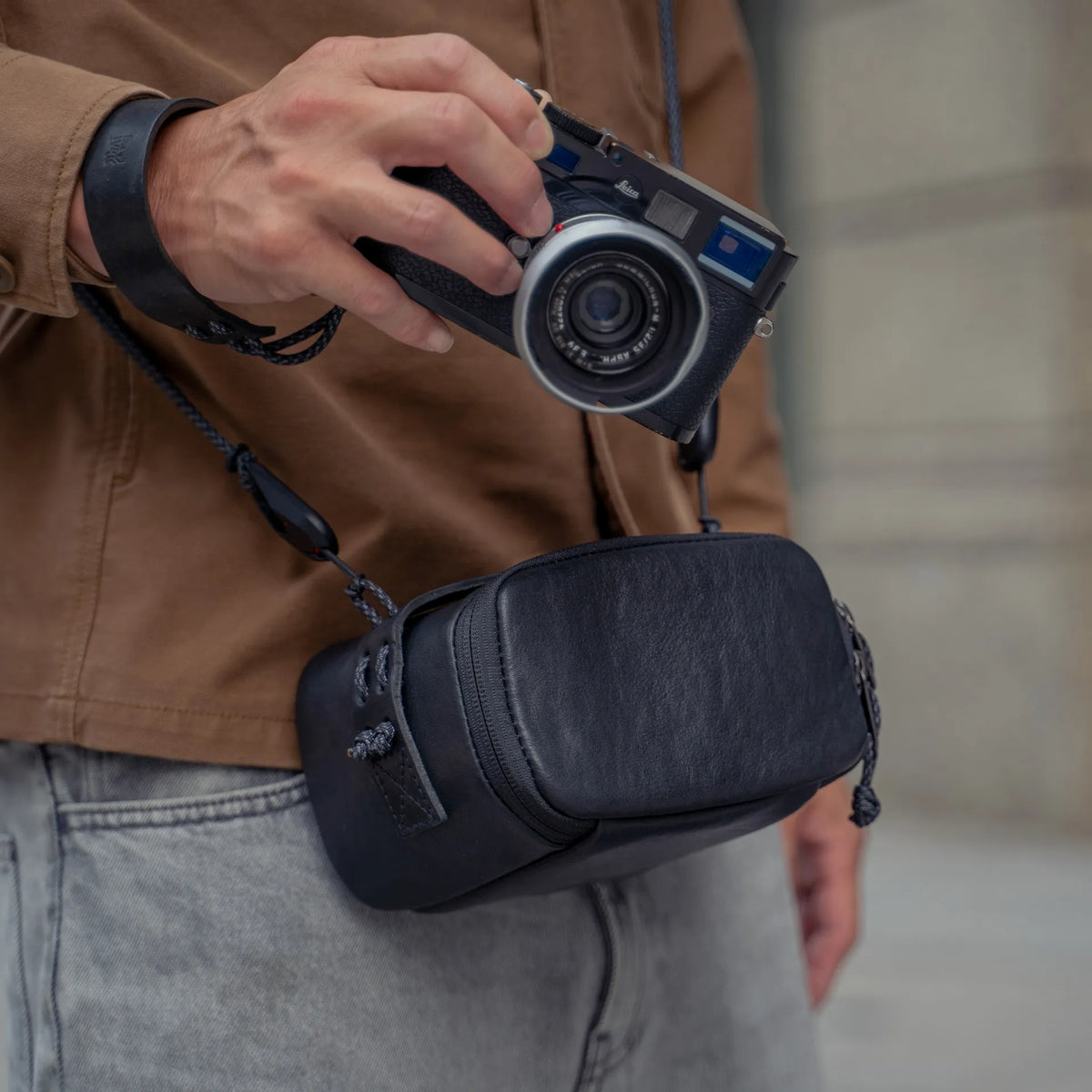 Photographer with a Leica M and the Wotancraft black leather pouch on a strap