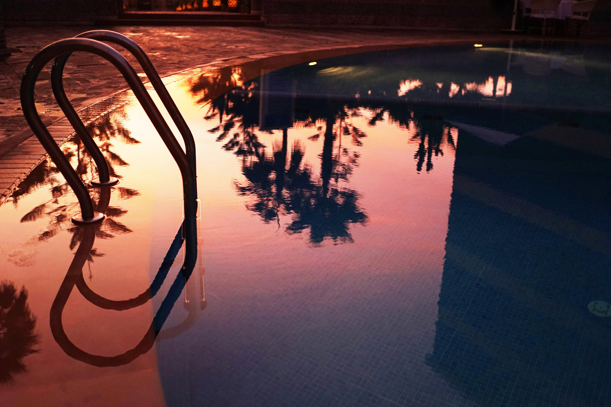 Swimming pool at sunset with palm tree reflections, sample from the Voigtlander Nokton Classic 35mm
