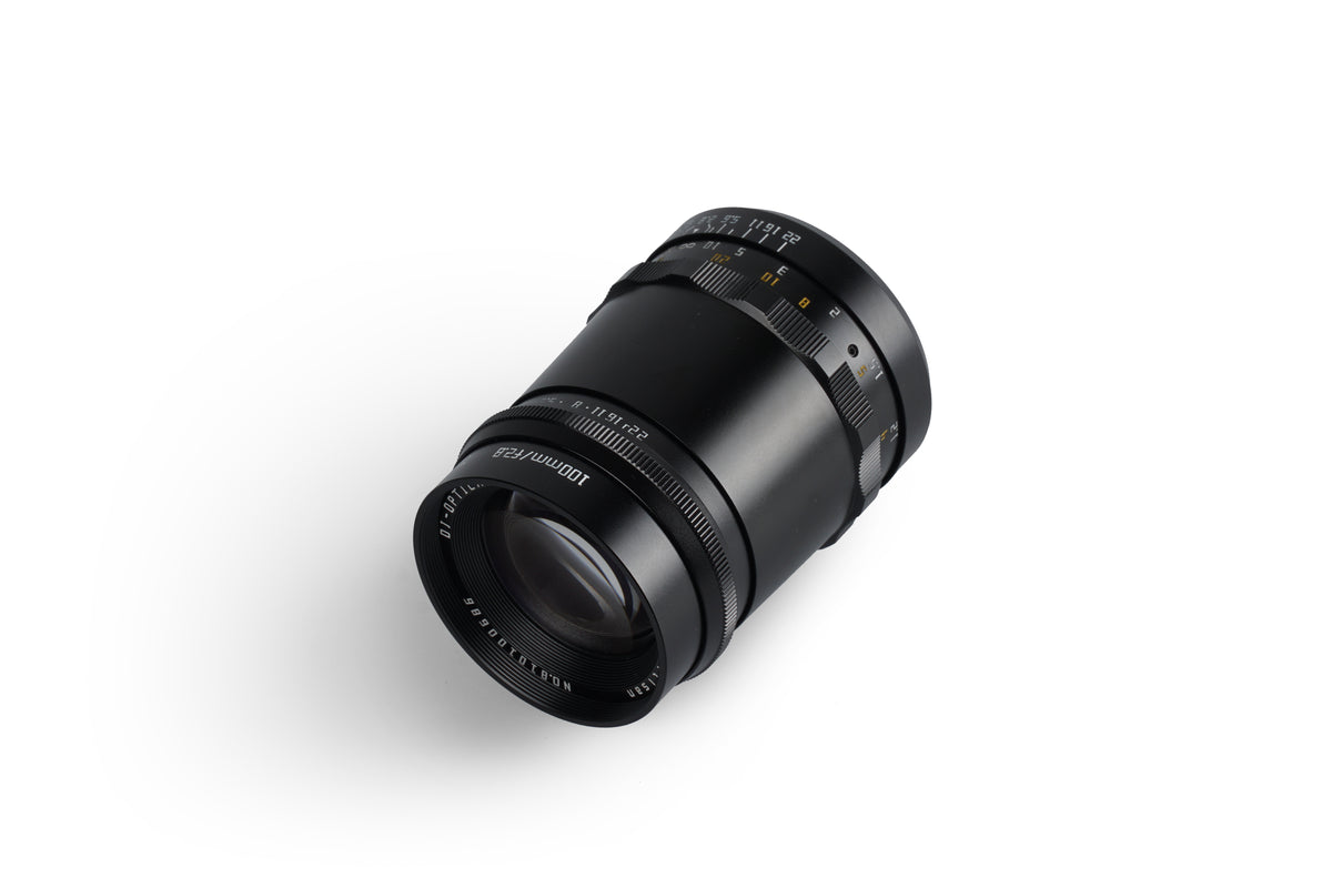 TTArtisan 100mm f/2.8 lens lying on its side, front element view
