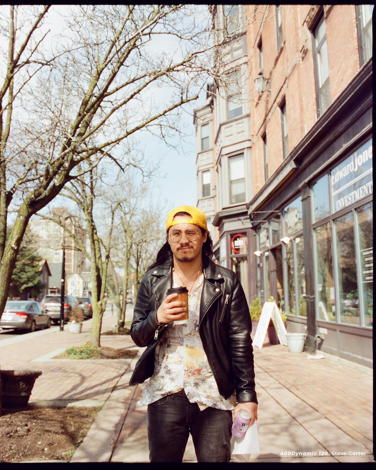 Man in a yellow cap with coffee on a city street, sample shot on CineStill 400D