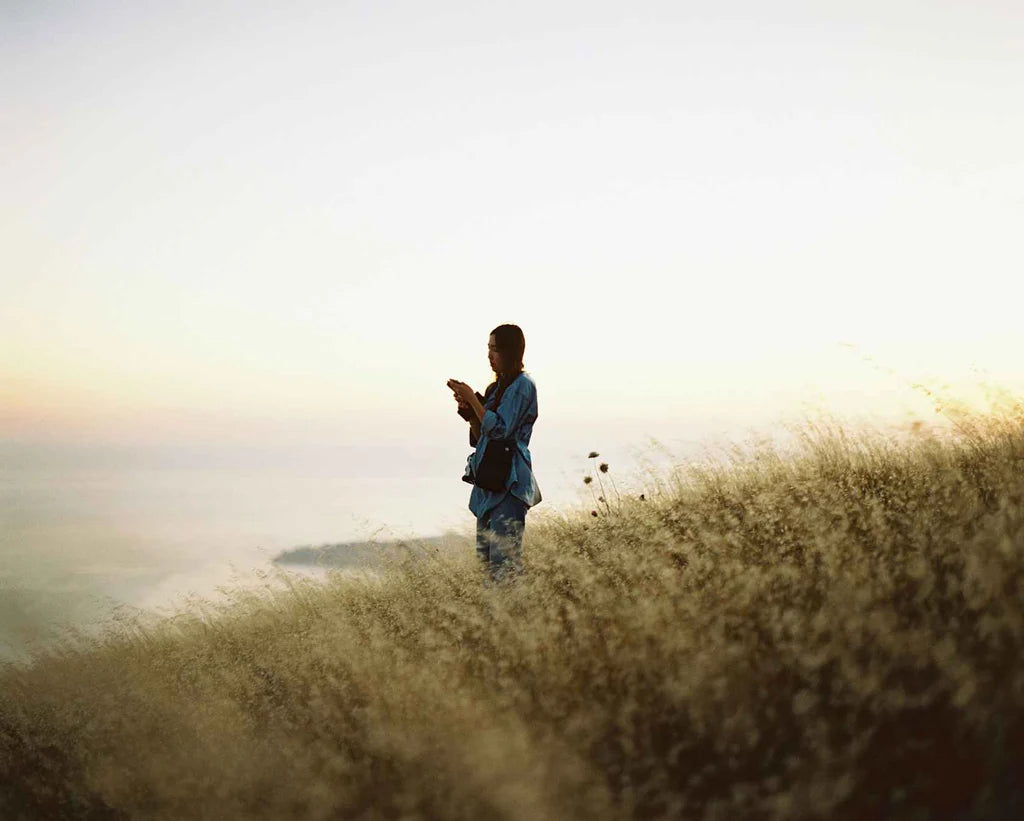 Woman standing in tall grass at sunset, sample shot on Kodak Ektacolor Pro 800