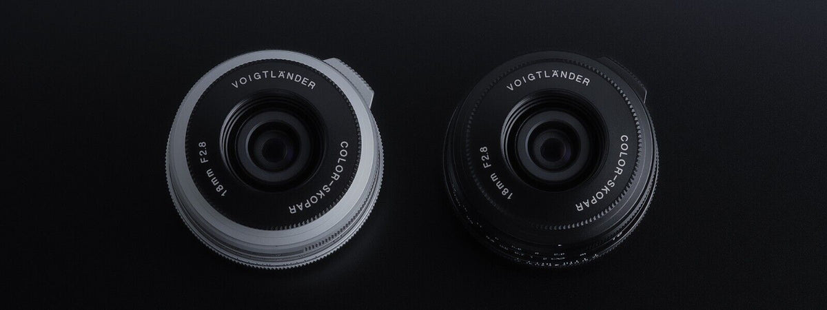 Voigtlander Color-Skopar 18mm f/2.8 pancake lenses in silver and black, front view