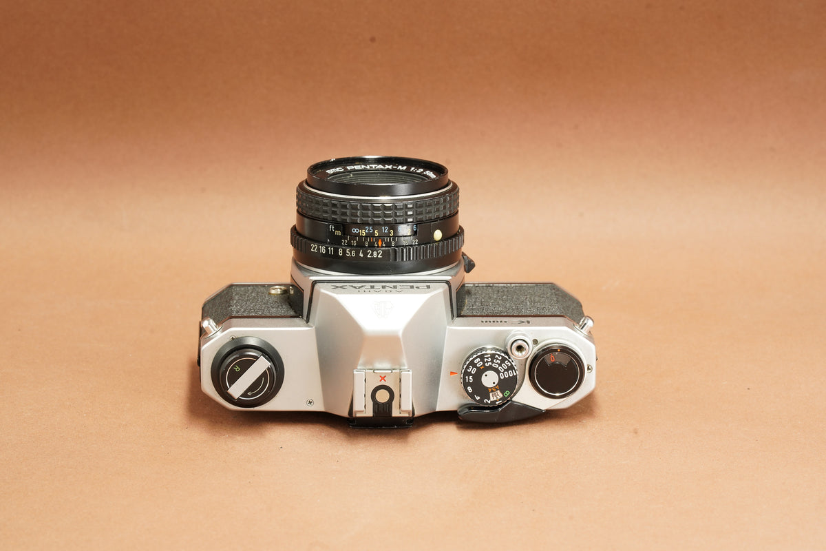 Pentax K1000 top view with shutter speed dial, film advance lever and 50mm lens