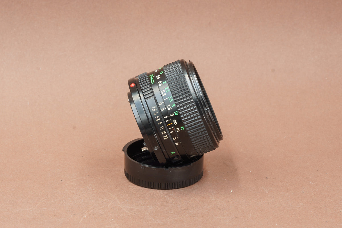Canon nFD 28mm f/2.8, side view on its rear cap
