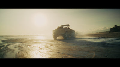 Off-road vehicle driving on a beach at sunset, sample still from the Thypoch Simera-C cine lens series