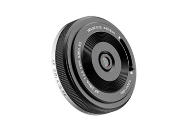 Viltrox AF 28mm f/4.5 VCM pancake lens, angled view of the front element and slide cap lever