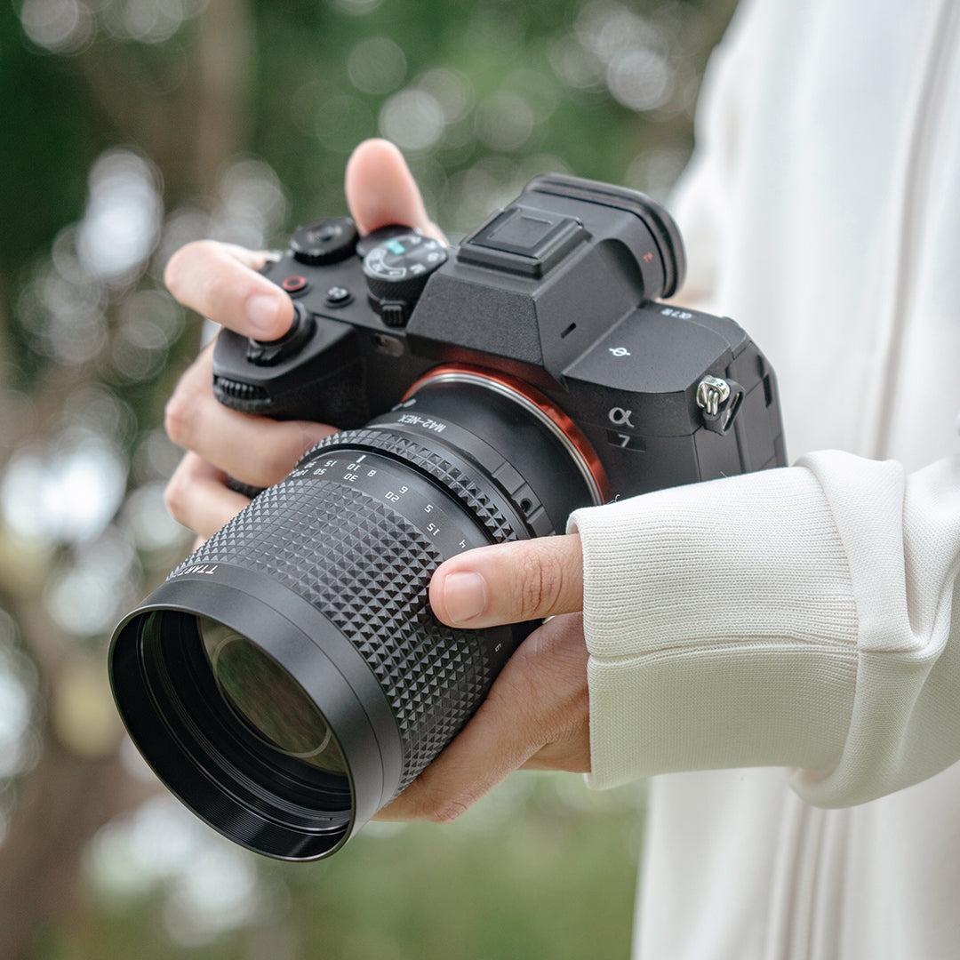 TTArtisan 250mm f/5.6 mirror lens on a Sony mirrorless camera, held in hand