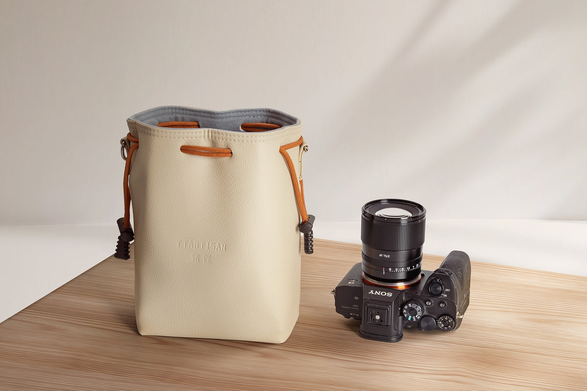 TTArtisan cream drawstring bag next to a Sony camera with a TTArtisan lens