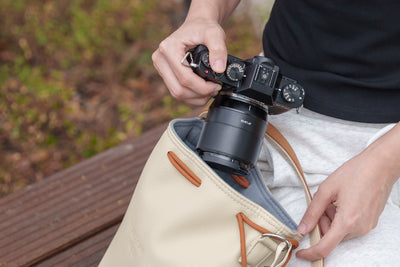 Hands taking a Fujifilm camera out of the TTArtisan drawstring bag