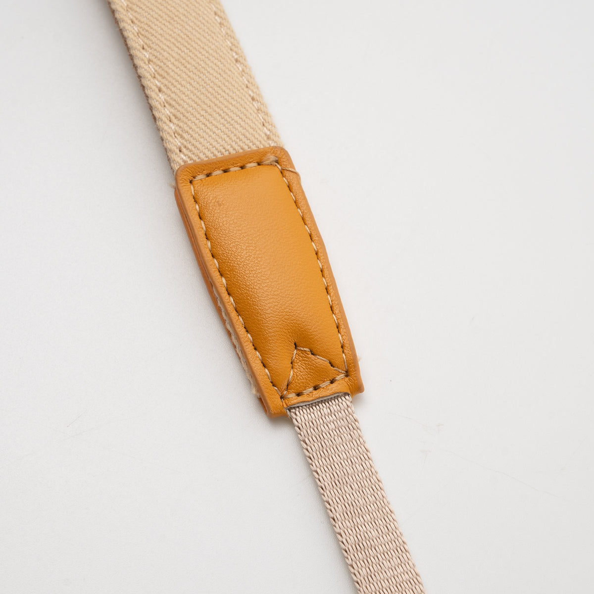 TTArtisan bag strap with tan leather tab, close-up