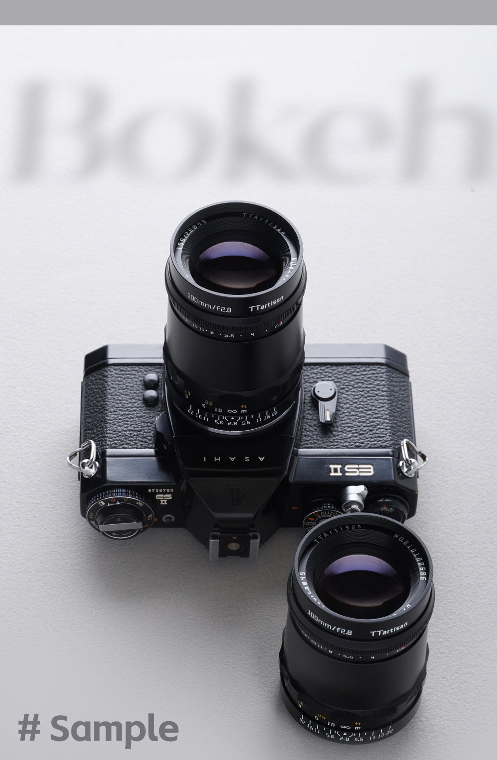 Two TTArtisan 100mm f/2.8 lenses, one fitted to an Asahi Pentax ES II film camera