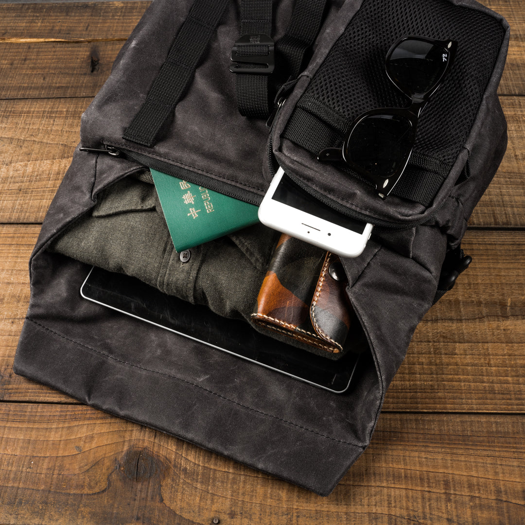 Wotancraft Pilot 7L charcoal bag open with passport, phone, sunglasses and clothes