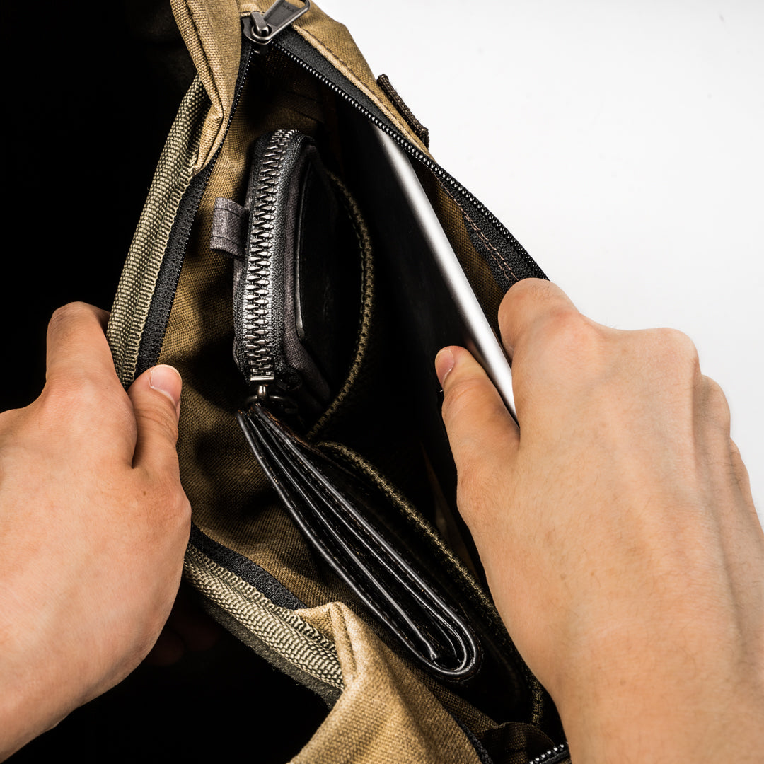 Hands opening the Wotancraft Pilot bag inner wallet and pen pocket
