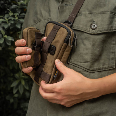 Hands holding the Wotancraft zipper and coin pouches clipped together