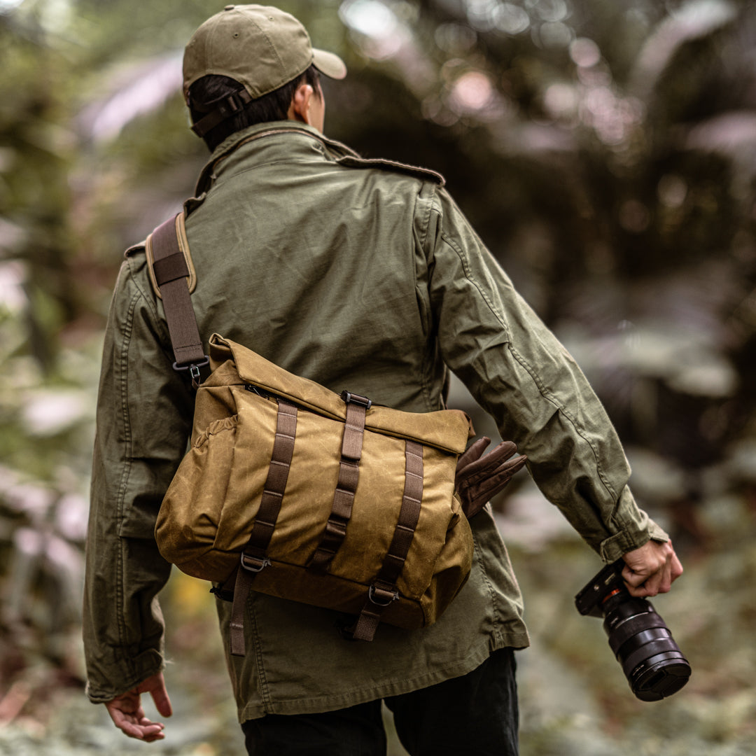 Photographer in a forest wearing the Wotancraft Pilot 10L khaki bag