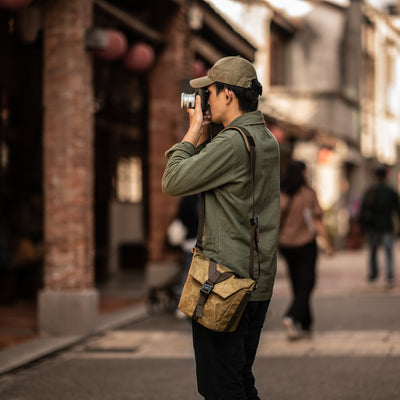 Photographer on a street with the Wotancraft Pilot 3.5L khaki bag