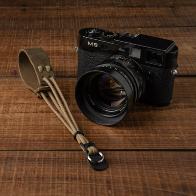 Wotancraft Parashooter Style 7 olive wrist strap next to a black Leica M9