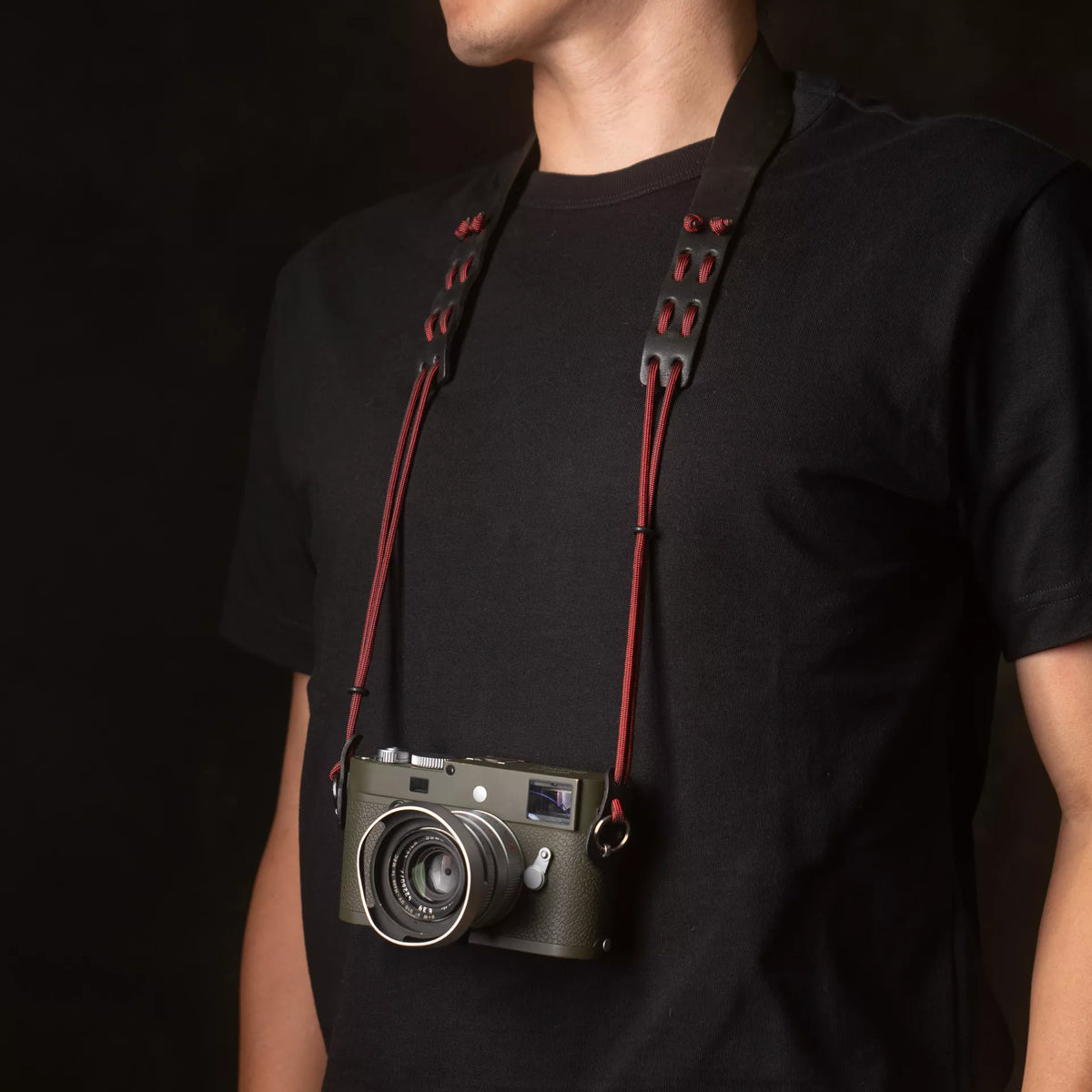 Person wearing an olive Leica M on the Wotancraft Parashooter Style 11 strap