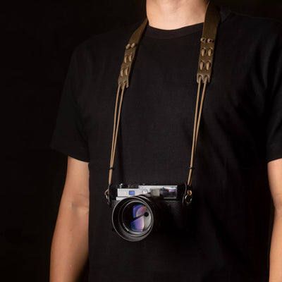 Person wearing a Leica camera on the Wotancraft Parashooter Style 7 olive strap