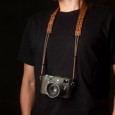 Person wearing a Leica M camera on the Wotancraft Parashooter Style 3 tan strap