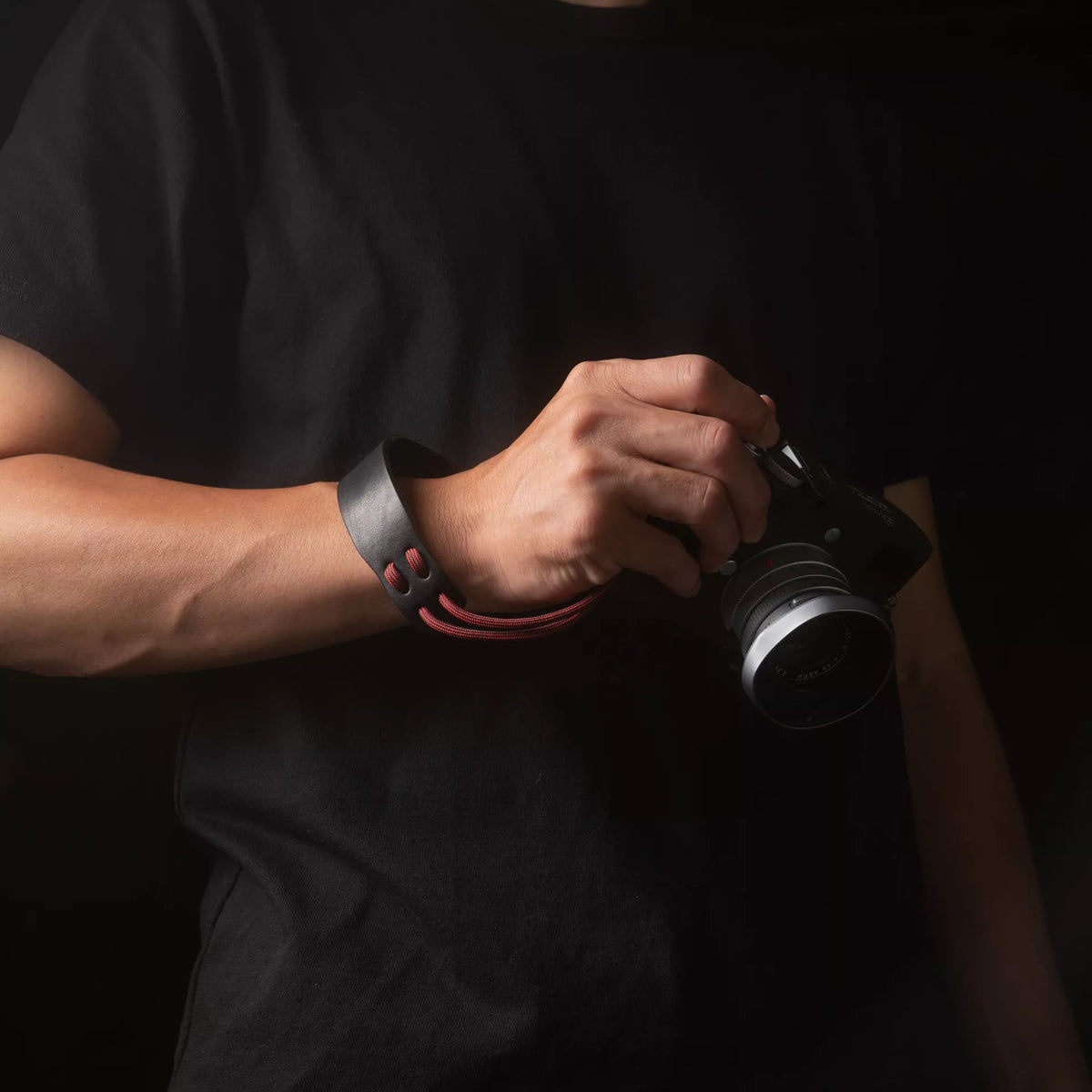 Man holding a Leica camera with the Wotancraft Parashooter Style 11 wrist strap
