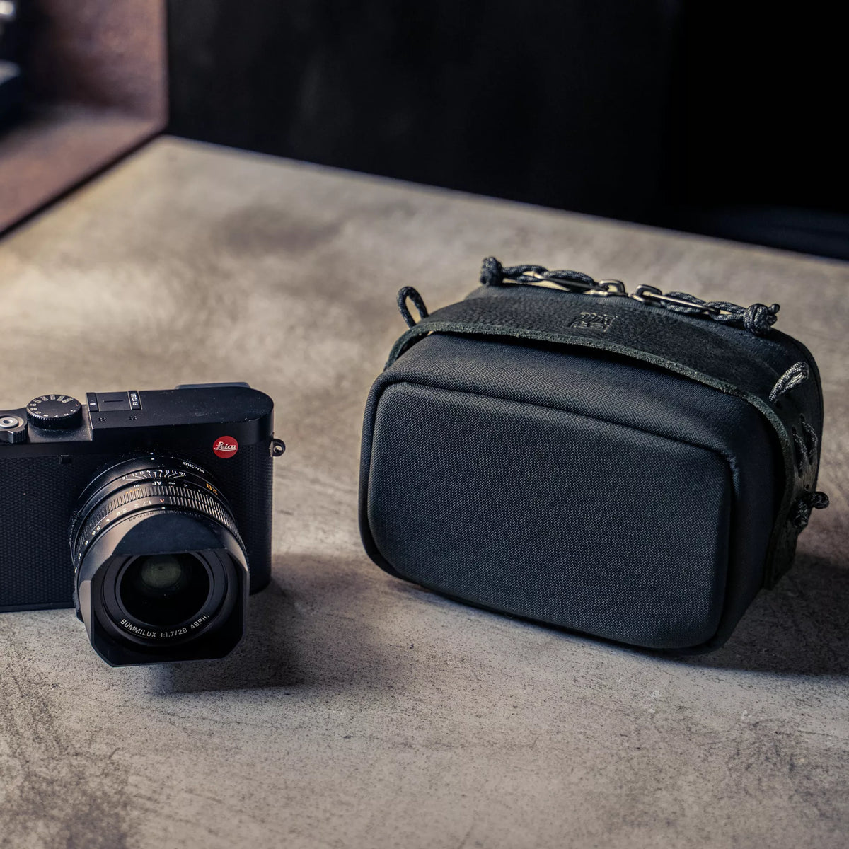 Wotancraft black canvas camera pouch next to a Leica Q