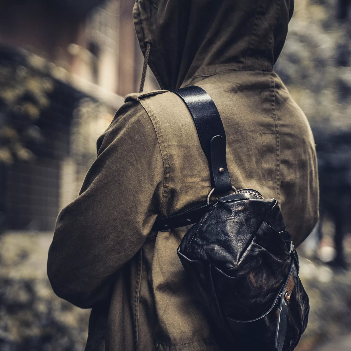 Wotancraft Mini Rider black leather sling worn across the shoulder, side view