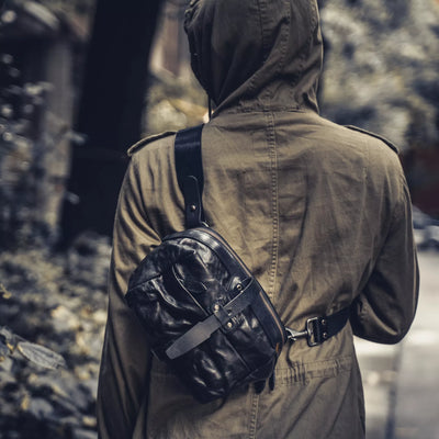 Person in a hooded jacket wearing the Wotancraft Mini Rider black sling on the back