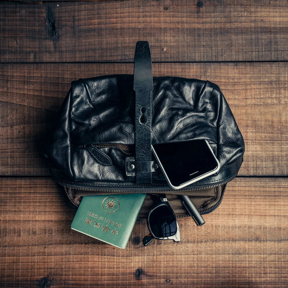 Wotancraft Mini Rider black leather bag with passport, phone and sunglasses