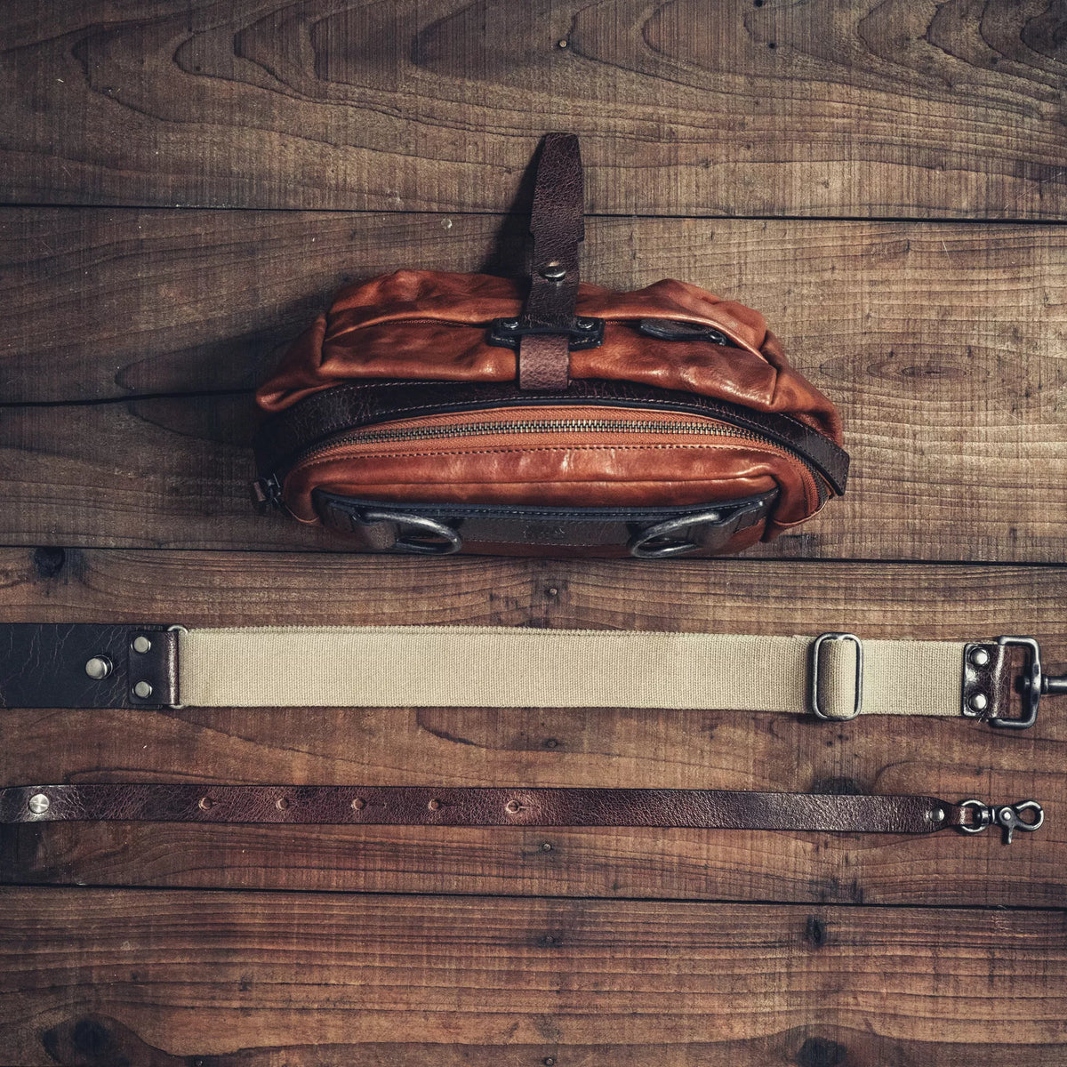 Wotancraft Mini Rider brown leather bag laid flat with its two shoulder straps