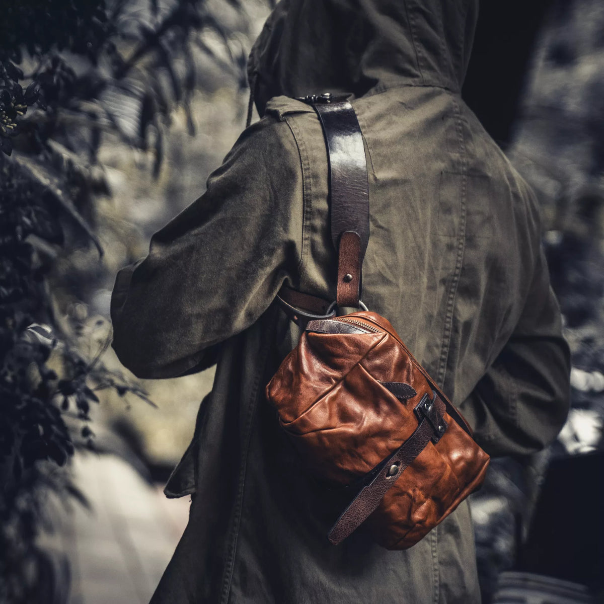 Wotancraft Mini Rider brown leather sling worn over the shoulder, side view