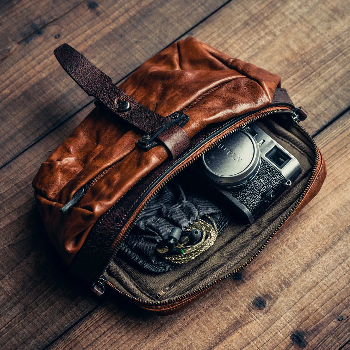 Wotancraft Mini Rider brown leather bag open with a Fujifilm camera inside