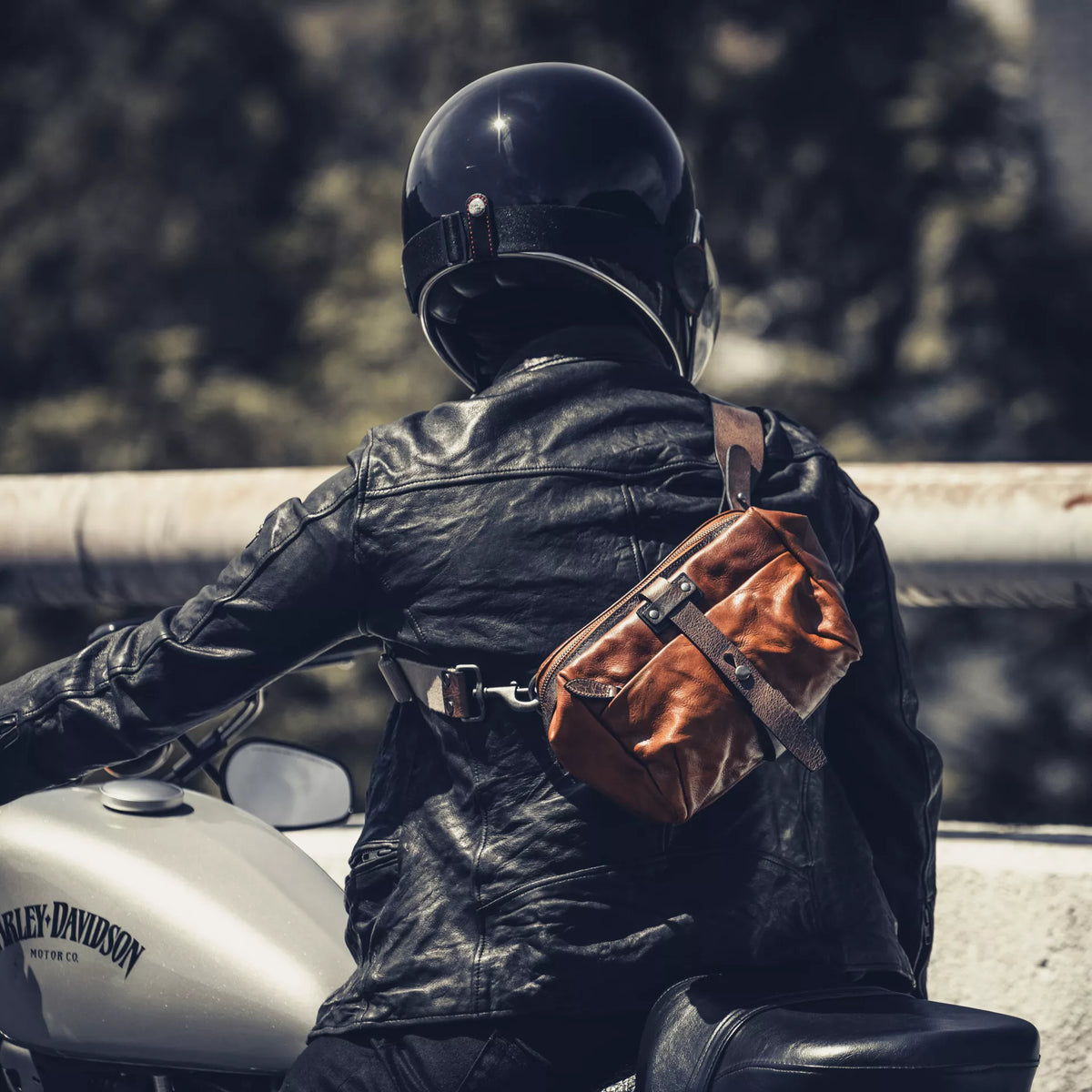 Motorcyclist on a Harley-Davidson wearing the Wotancraft Mini Rider brown leather bag