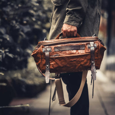 Man carrying the Wotancraft Night Rider brown leather bag by the handle