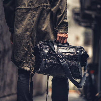 Man holding the Wotancraft Lightning Rider black leather bag with shoulder strap