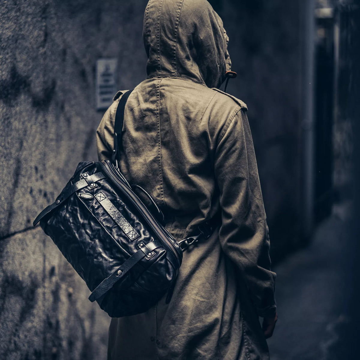 Person in a hooded jacket wearing the Wotancraft Lightning Rider black leather sling