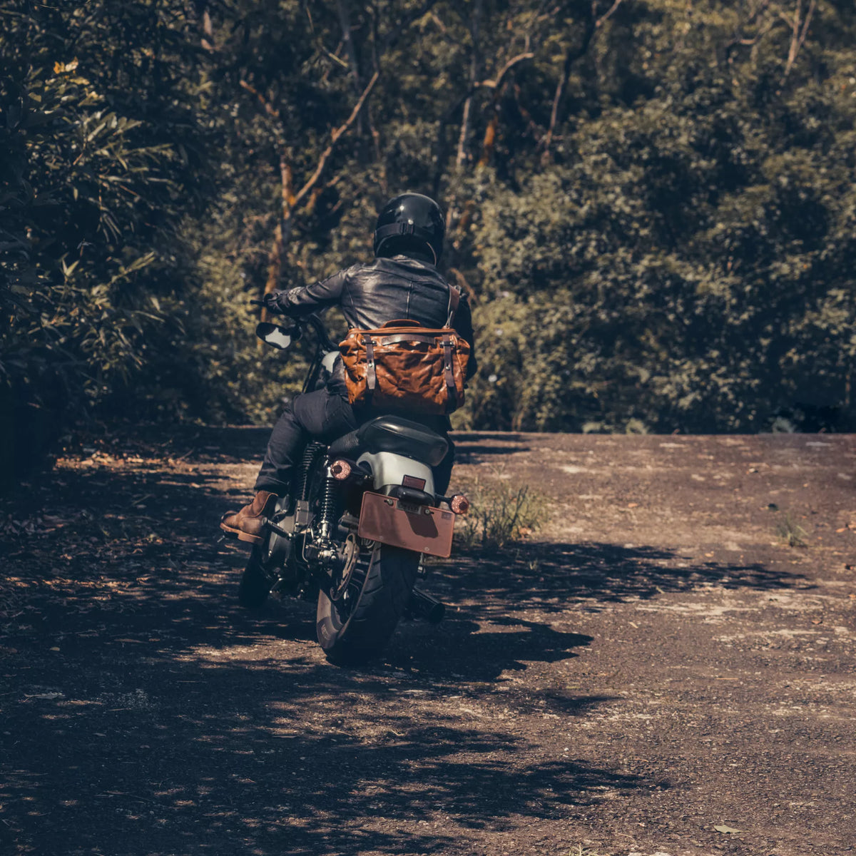 Motorcyclist riding away with the Wotancraft Lightning Rider brown leather bag on the back