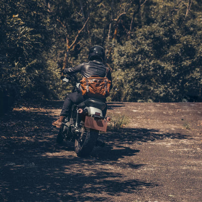 Motorcyclist riding away with the Wotancraft Lightning Rider brown leather bag on the back