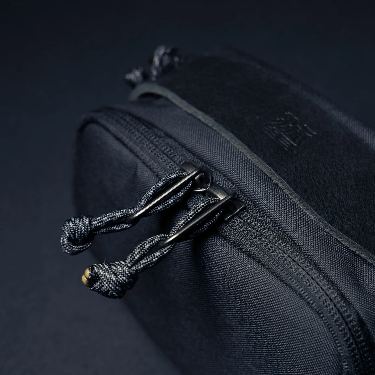 Wotancraft black canvas pouch double zip pulls with paracord, close-up